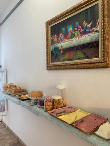 a table with a painting on the wall with food on it at FAMÍLIA CHARLEAUX in Aparecida
