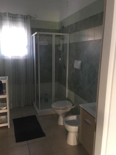 a bathroom with a toilet and a shower at Case sul mare in Palau