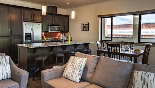a living room with a couch and a kitchen at Lux Downtown Condo by Revelstoke Vacations in Revelstoke