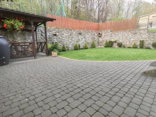 a brick patio with a stone wall and a pavilion at Apartament JOANNA in Sanok