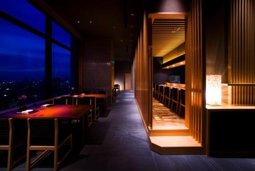 a restaurant with tables and a view of the city at Hotel Monterey Grasmere Osaka in Osaka