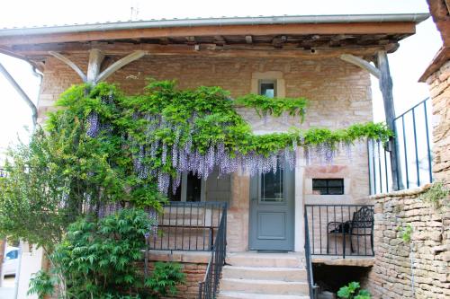 une maison avec des glycines sur la porte d'entrée dans l'établissement LE CLOS DES PIERRES ROUGES, à Burgy