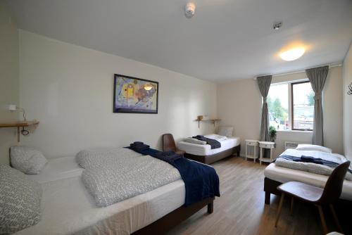 1 dormitorio con 2 camas y sofá en Klausturhof Guesthouse en Kirkjubæjarklaustur