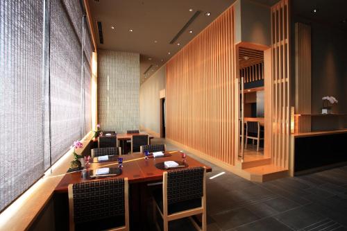 a restaurant with a table and chairs in a room at Hotel Monterey Grasmere Osaka in Osaka