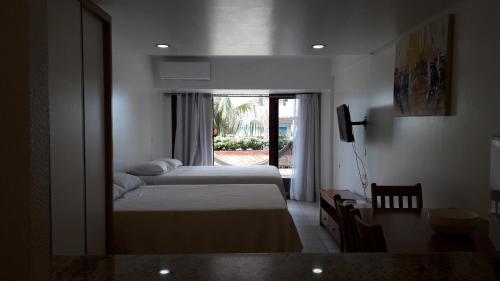 a hotel room with two beds and a window at Imo Apart Pipa's Ocean in Pipa