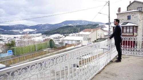 a man in a suit standing on a white fence at Chez Mary in Vanosc
