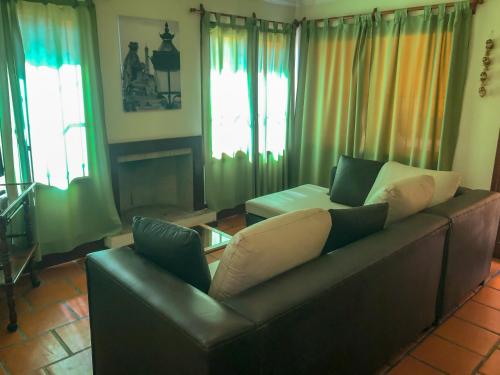 a living room with a leather couch and windows at Casa en B° Tres Cerritos, Salta Capital. Alquiler Temporal in Salta