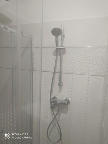 La salle de bains est pourvue d'une douche avec un pommeau de douche. dans l'établissement Modern Apartman, à Szeged