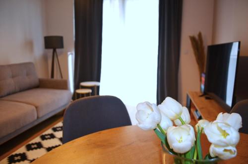 un jarrón de flores sobre una mesa en la sala de estar en Lighter Apartment, en Gdansk