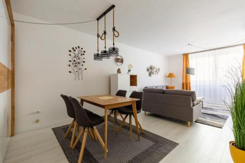 een woonkamer met een tafel en een bank bij Flat White Apartment in Boedapest