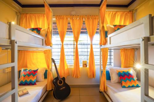 a bedroom with two bunk beds and a guitar at goSTOPS Coorg in Madikeri