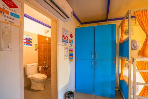 a bathroom with a toilet and a blue cabinet at goSTOPS Coorg in Madikeri