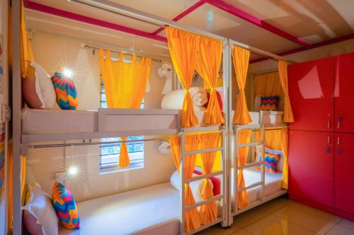 a bedroom with two bunk beds with orange curtains at goSTOPS Coorg in Madikeri