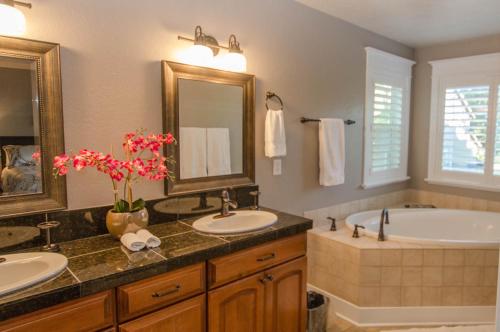 een badkamer met 2 wastafels, een bad en een spiegel bij Separation Canyon Retreat in Flagstaff