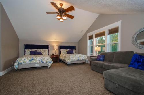 a bedroom with two beds and a couch and a ceiling fan at Separation Canyon Retreat in Flagstaff