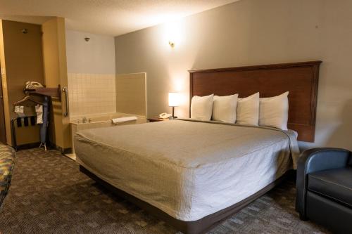 a hotel room with a bed and a chair at Governors Inn a Travelodge by Wyndham in Pierre