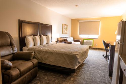 a hotel room with a bed and a couch at Governors Inn a Travelodge by Wyndham in Pierre