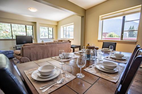 a dining room with a table with plates and wine glasses at Selkirk Snug by Revelstoke Vacations in Revelstoke