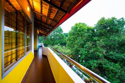 a balcony of a building with a view of trees at goSTOPS Coorg in Madikeri
