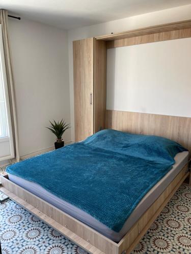 une chambre avec un grand lit avec une couverture bleue dans l'établissement LA RADE - Centre Ville - Balcon - Clim - Neuf, à Cassis