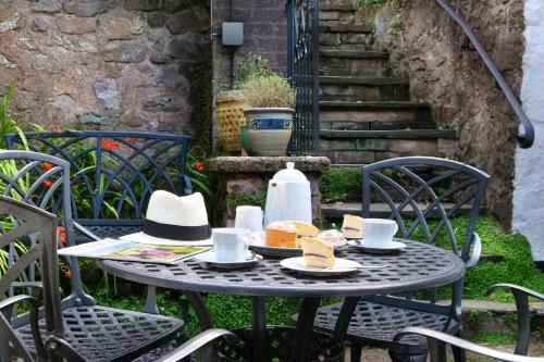 a table with food and hats on top at The Oval in Dunster