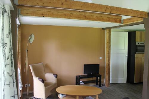 a living room with a table and a tv at Apartment 't Zwaluwnest Luttenberg in Luttenberg