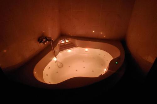 a bath tub in a bathroom with lights on it at L'IDYLLE - Studio Cocooning avec Jacuzzi in Mâcon