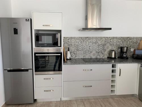 a kitchen with a refrigerator and a microwave at Joia da Casa House with private Pool in Sobral