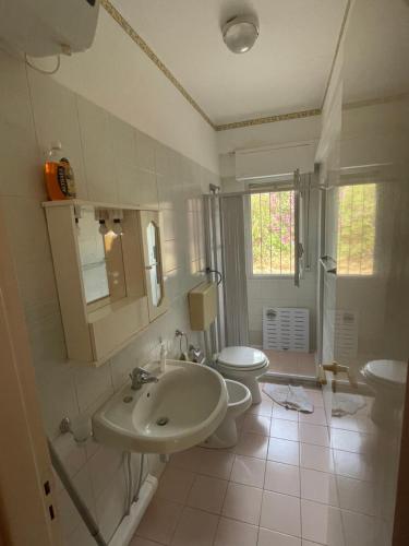 a white bathroom with a sink and a toilet at Accogliente Appartamento Costa Makauda in Ribera