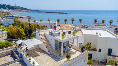 eine Luftansicht eines Hauses mit Meerblick im Hintergrund in der Unterkunft Le Pativite Luxury Apartments by HDSalento in Santa Maria di Leuca