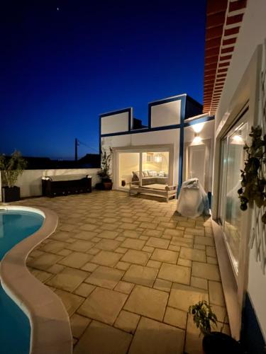 a villa with a swimming pool at night at Joia da Casa in Sobral