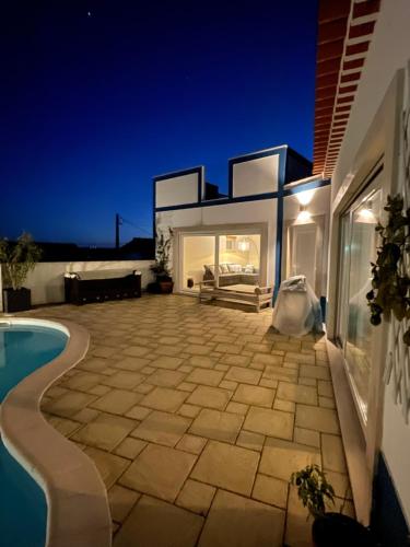 a villa with a swimming pool at night at Joia da Casa House with private Pool in Sobral