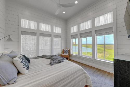 a bedroom with white walls and windows and a bed at Turtle Ransas & Seaside Paradise in Port Aransas