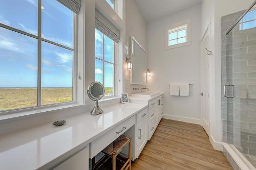 a white bathroom with a sink and a window at Turtle Ransas & Seaside Paradise in Port Aransas