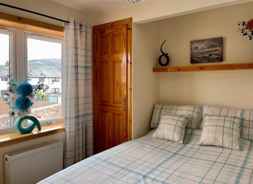 a bedroom with a bed and a window at Feel at home while you roam in Caol