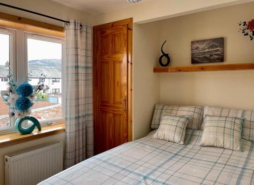 a bedroom with a bed and a window at Failte Mhor in Fort William