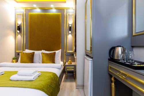 a hotel room with a bed with a green blanket at Santa Rio Taxim in Istanbul