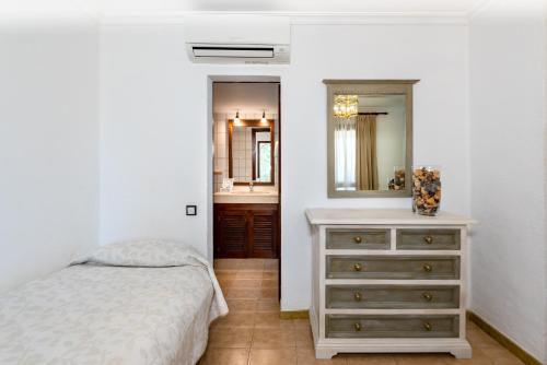 a bedroom with a bed and a bathroom with a sink at Finca Hotel Rural Predio Son Serra in Can Picafort