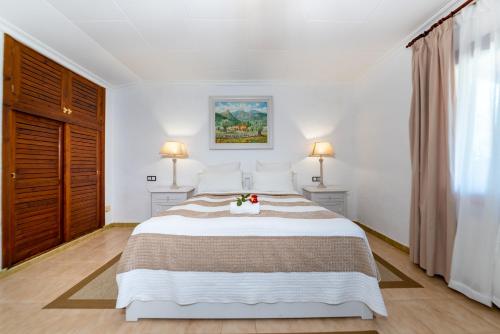 a bedroom with a large bed and two lamps at Finca Hotel Rural Predio Son Serra in Can Picafort
