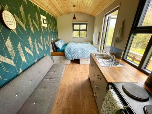 una casetta minuscola con un letto e un lavandino dentro di Shepherds Hut Glamping a Bantry