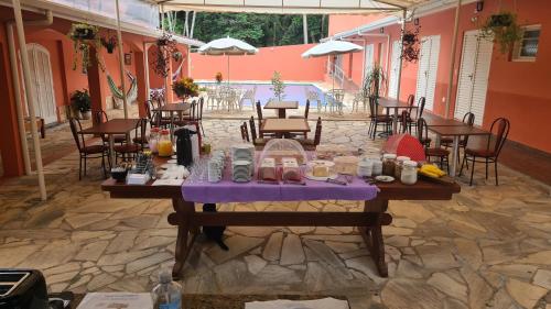 a table with food on it in a patio at Pousada Casa Doce Vida in Águas de Lindóia