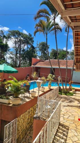a resort with a swimming pool and palm trees at Pousada Casa Doce Vida in Águas de Lindóia