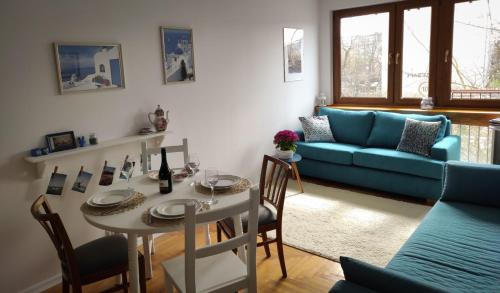 sala de estar con mesa y sofá azul en JLS Apartament z parkingiem przy plaży en Gdansk