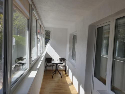 um corredor de uma casa com uma mesa e algumas janelas em Butas Nidos centre em Nida