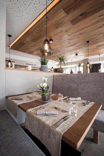 a dining room with a table and some lights at Vitalpina Hotel Waldhof in Rablà