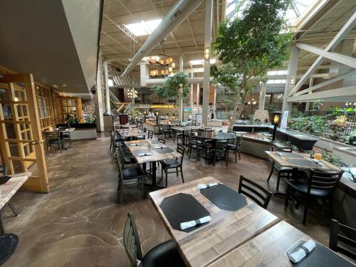 an empty restaurant with wooden tables and chairs at The Academy Hotel Colorado Springs in Colorado Springs
