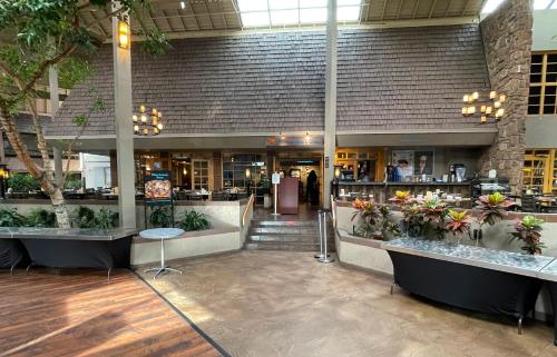 a lobby of a restaurant with plants on display at The Academy Hotel Colorado Springs in Colorado Springs
