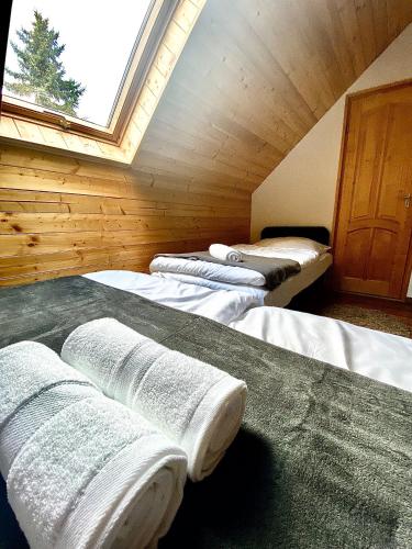 a room with three beds in a room with a window at Fakanalas Fogadó in Pásztó