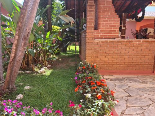 a garden with flowers in front of a house at Pousada Casa Doce Vida in Águas de Lindóia