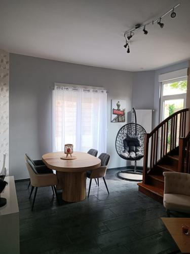 een woonkamer met een tafel en stoelen bij Maison chaleureuse avec netflix et ps5 in Valenciennes